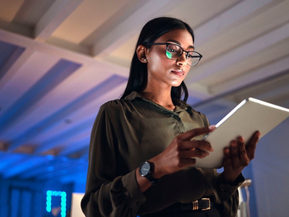 imagem mostra uma mulher segurando um tablet em um ambiente de transformação digital