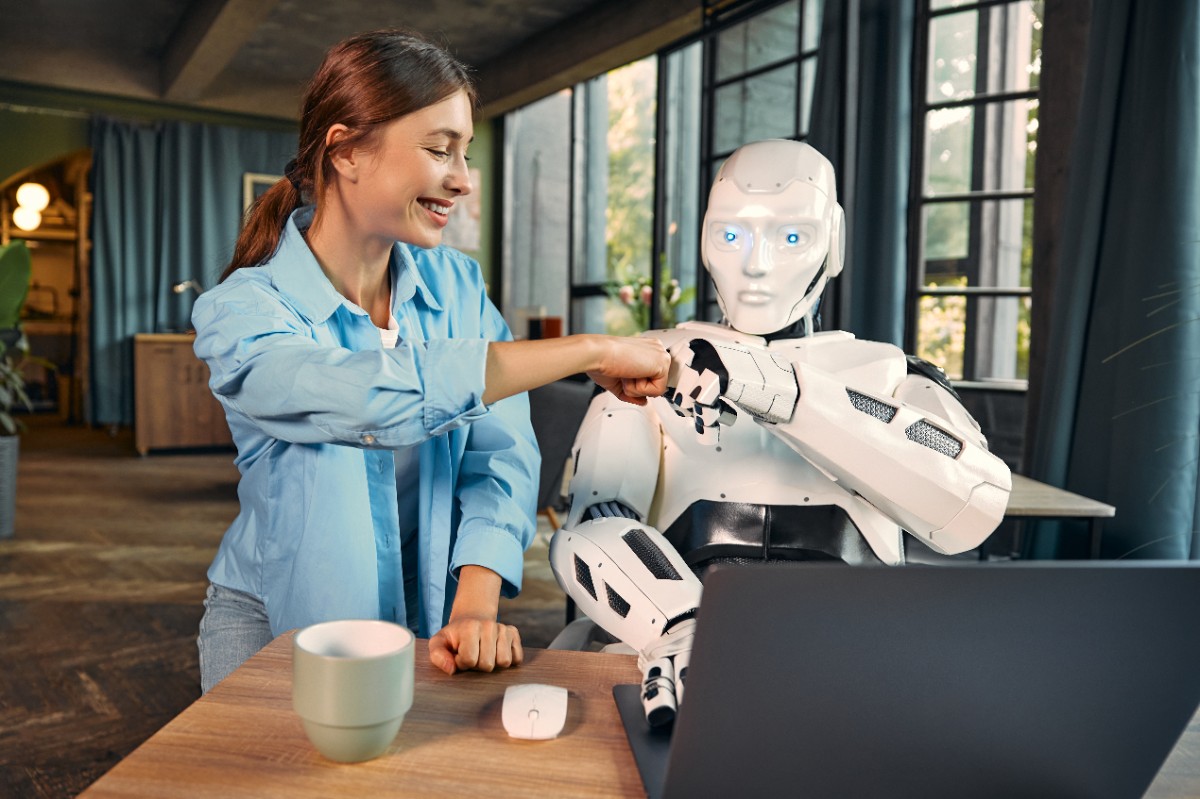 la imagen muestra a una mujer feliz saludando a un robot, simbolizando una asociación de trabajo.