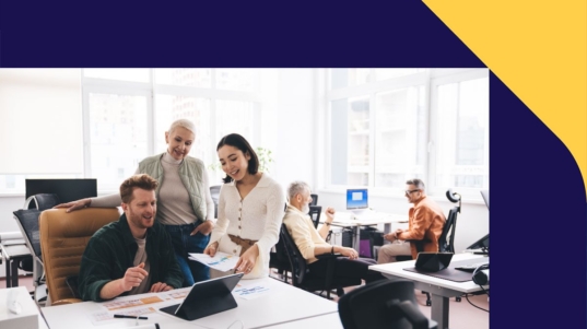 imagen muestra a tres personas en una oficina financiera observando una notebook con informes.