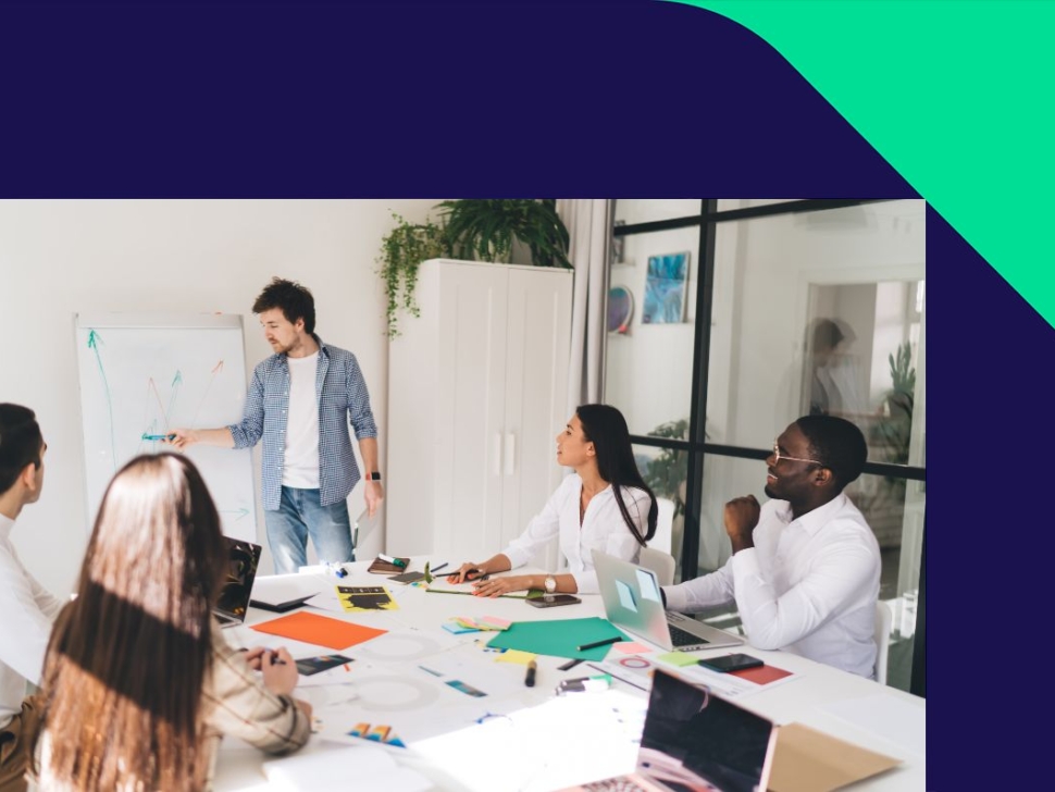 imagem mostra um grupo de pessoas em reunião em um escritório.