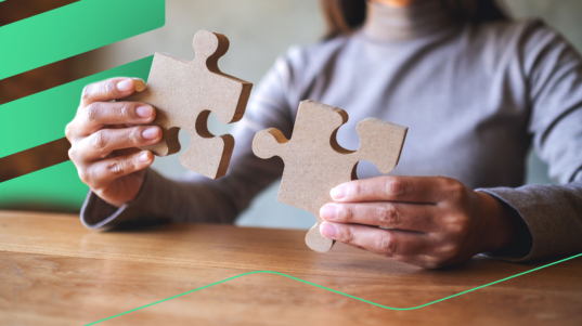 closeup-image-woman-holding-putting-piece-wooden-jigsaw-puzzle-together