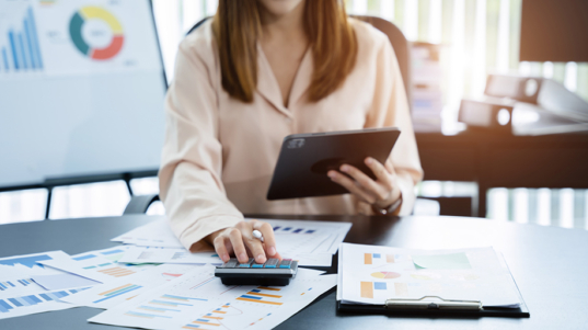 imagem mostra uma mulher usando uma plataforma de gestão financeira em seu iPad.